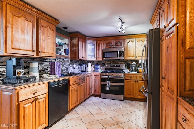 kitchen with light tile patterned floors, backsplash, stainless steel appliances, and hanging light fixtures