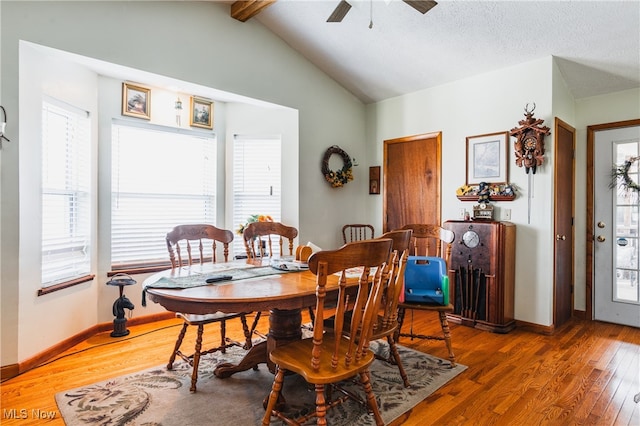 dining room featuring a textured ceiling, lofted ceiling with beams, dark hardwood / wood-style floors, and ceiling fan