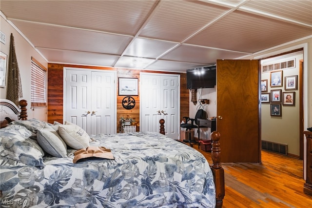 bedroom featuring wood walls and hardwood / wood-style flooring