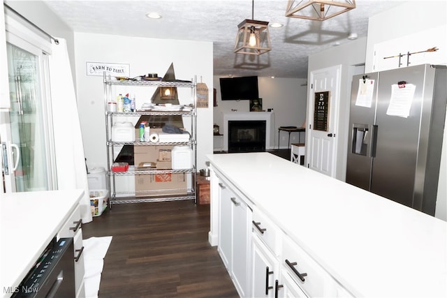 kitchen with appliances with stainless steel finishes, a textured ceiling, dark wood-type flooring, pendant lighting, and white cabinets