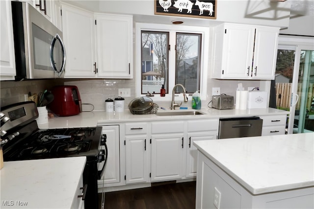 kitchen featuring decorative backsplash, appliances with stainless steel finishes, dark hardwood / wood-style flooring, sink, and white cabinets