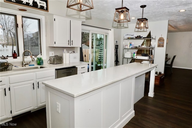 kitchen with white cabinets, a textured ceiling, stainless steel dishwasher, and a healthy amount of sunlight