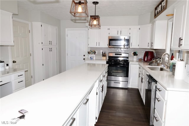 kitchen featuring a center island, hanging light fixtures, dark hardwood / wood-style floors, white cabinetry, and stainless steel appliances