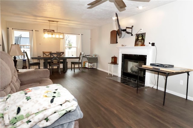 living room with dark hardwood / wood-style floors, a tiled fireplace, plenty of natural light, and ceiling fan