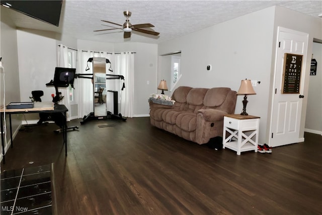 living room featuring a textured ceiling, dark hardwood / wood-style flooring, and ceiling fan