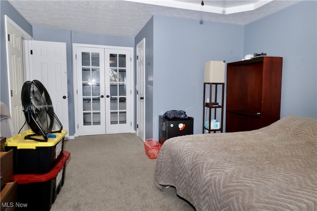 bedroom with carpet floors, a textured ceiling, and french doors