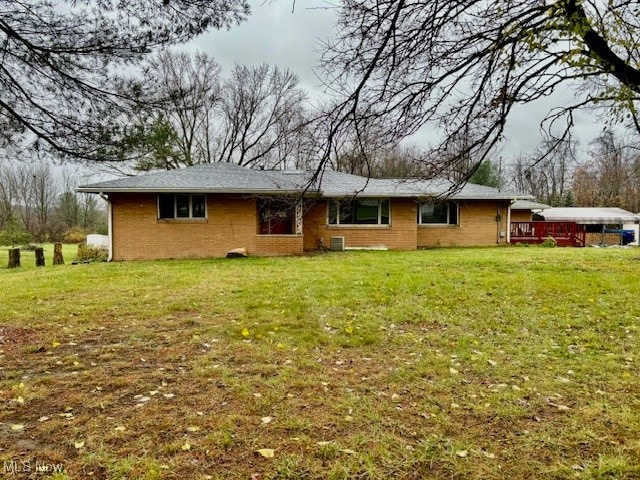 view of front facade with a deck and a front lawn