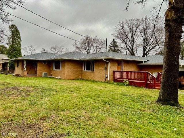 back of house with a deck, cooling unit, and a lawn