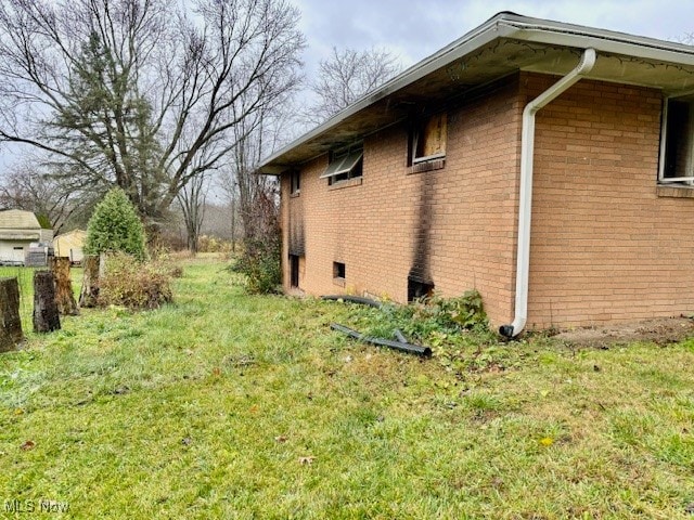 view of side of home with a lawn