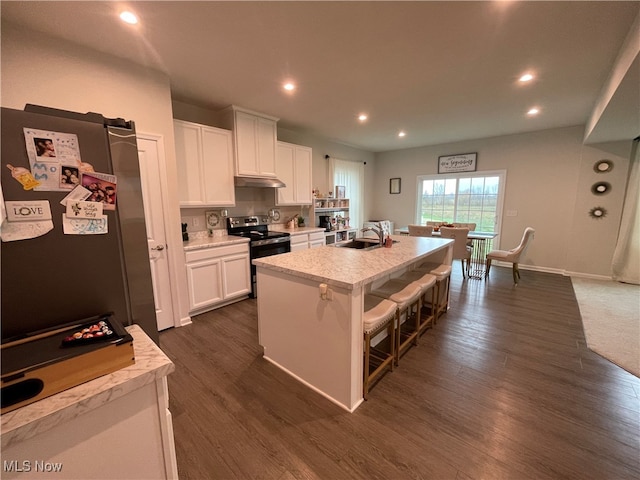 kitchen featuring a kitchen bar, appliances with stainless steel finishes, sink, white cabinetry, and an island with sink