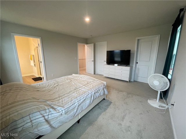 carpeted bedroom featuring ensuite bath