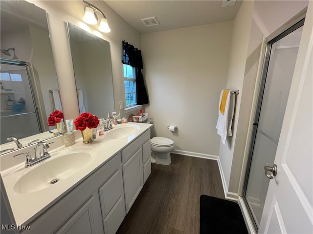 bathroom with toilet, a shower with door, vanity, and hardwood / wood-style flooring