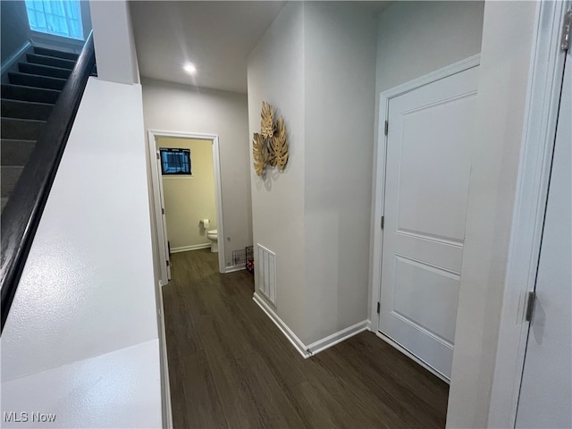 corridor with dark hardwood / wood-style flooring