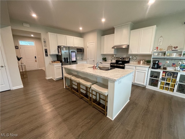 kitchen featuring a kitchen breakfast bar, an island with sink, appliances with stainless steel finishes, dark hardwood / wood-style flooring, and white cabinetry