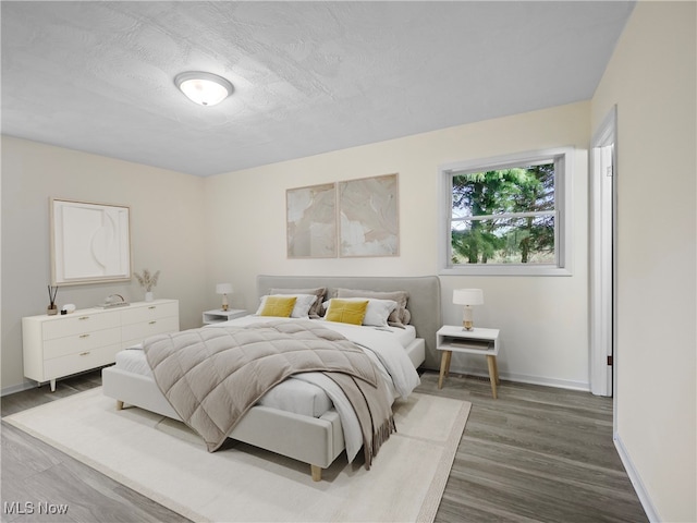 bedroom featuring a textured ceiling and hardwood / wood-style flooring