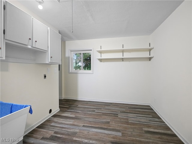 laundry room featuring cabinets, a textured ceiling, hookup for an electric dryer, and dark wood-type flooring