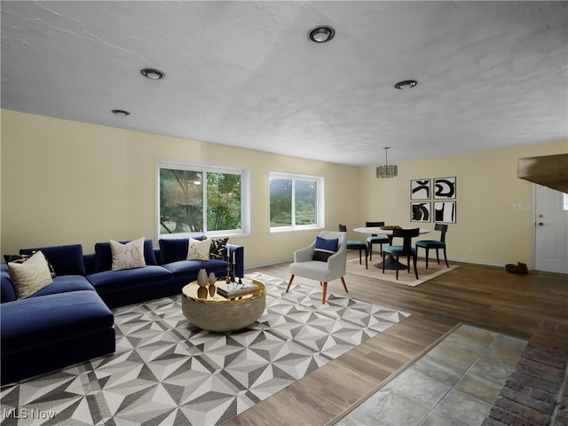 living room featuring light wood-type flooring and a notable chandelier