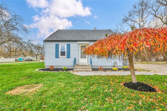 bungalow-style home with a front yard