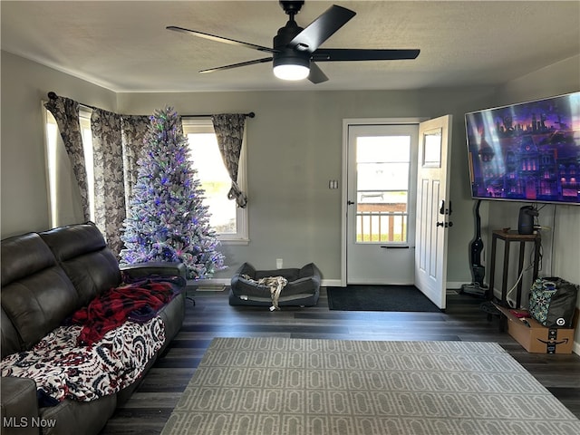 living room featuring a textured ceiling, plenty of natural light, dark wood-type flooring, and ceiling fan