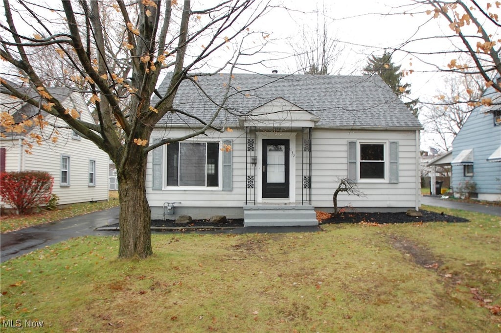 bungalow-style home featuring a front yard