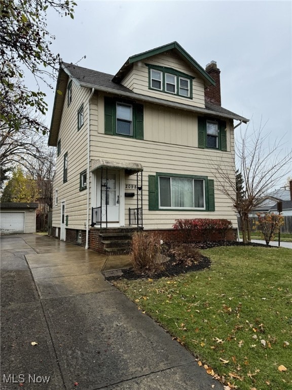 view of front property featuring an outbuilding, a front lawn, and a garage