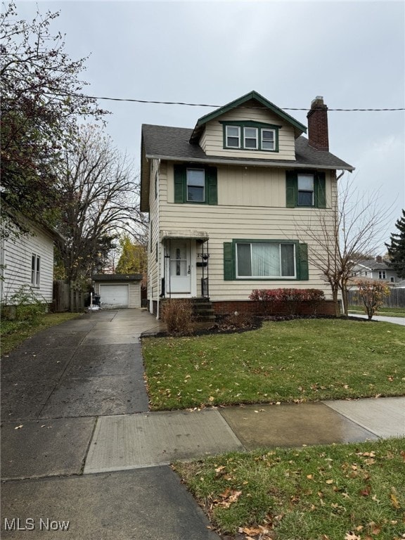 view of front property featuring a front yard, a garage, and an outdoor structure