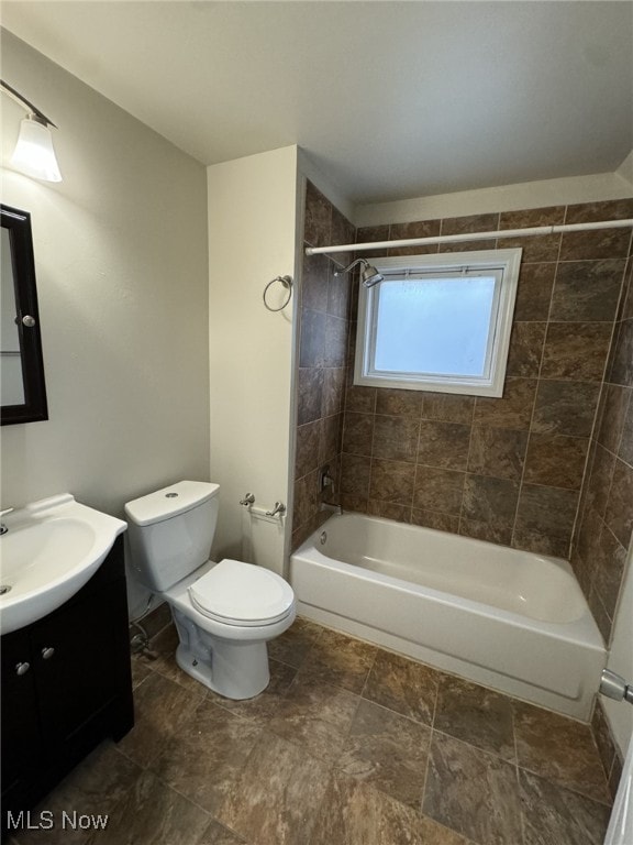 full bathroom with vanity, tiled shower / bath combo, and toilet