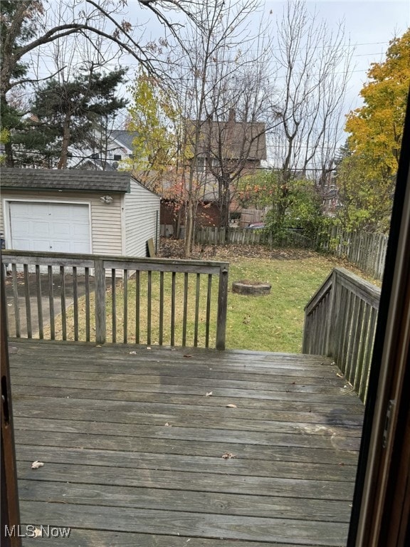 deck with a lawn, a garage, and an outdoor structure