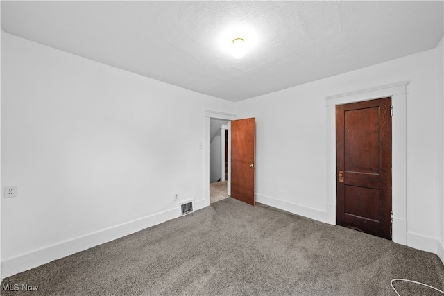 carpeted empty room with a textured ceiling