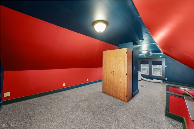 additional living space featuring carpet and vaulted ceiling