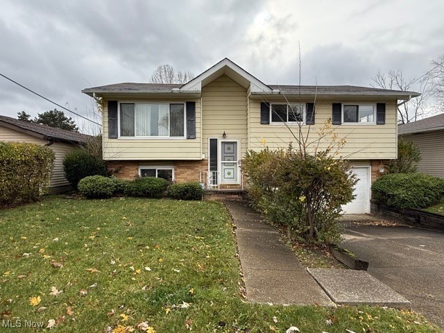 bi-level home with a garage and a front yard