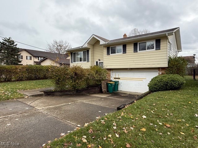 view of front of property featuring a garage and a front lawn