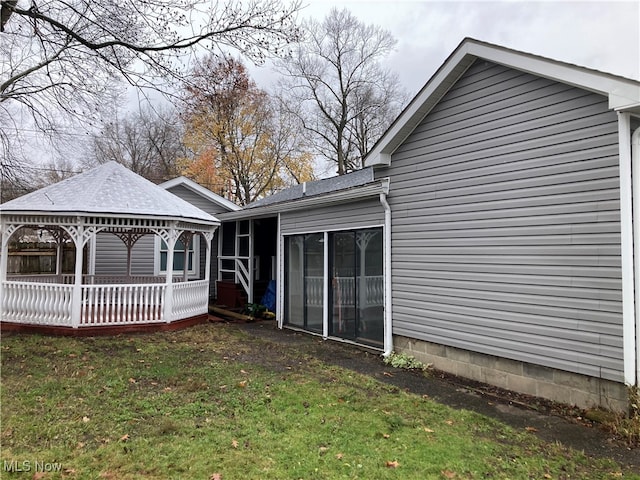 back of property with a gazebo and a yard