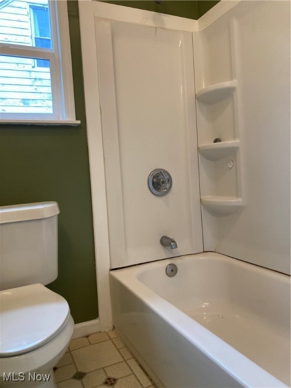 bathroom featuring tile patterned flooring, toilet, and shower / bathtub combination