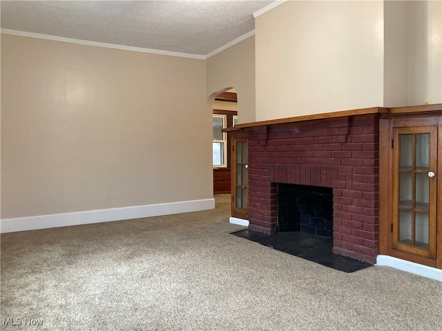 unfurnished living room featuring a fireplace, a textured ceiling, carpet floors, and ornamental molding