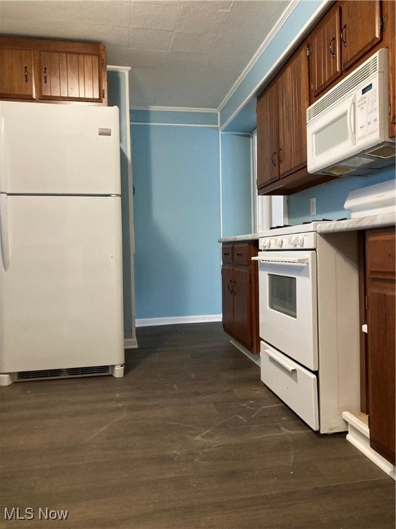 kitchen featuring crown molding, dark hardwood / wood-style flooring, and white appliances