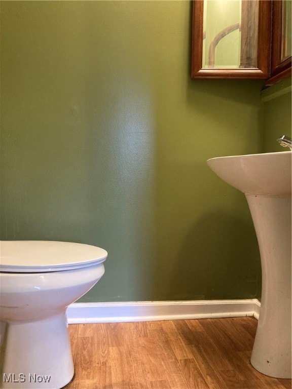 bathroom featuring hardwood / wood-style flooring and toilet