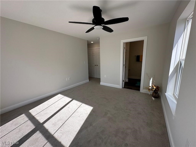 unfurnished bedroom with ensuite bath, ceiling fan, a closet, and carpet