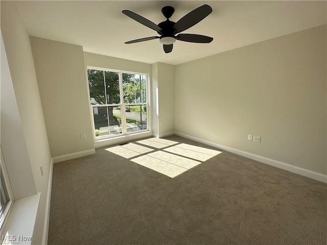 carpeted spare room featuring ceiling fan