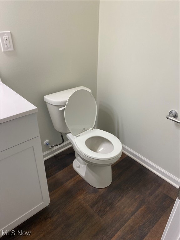 bathroom with hardwood / wood-style floors, vanity, and toilet