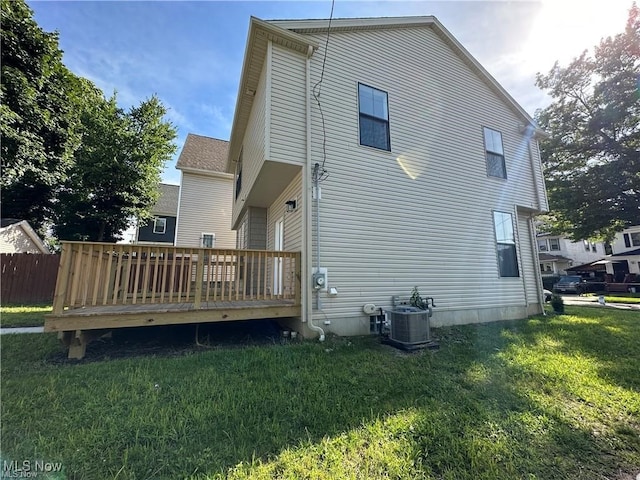 back of property featuring a wooden deck, a yard, and central AC unit