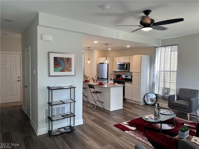 living room with ceiling fan and dark wood-type flooring