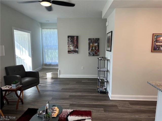 living room with ceiling fan and dark wood-type flooring