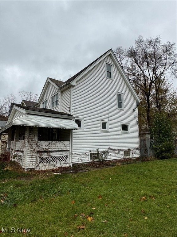 view of side of home featuring a yard and central AC unit