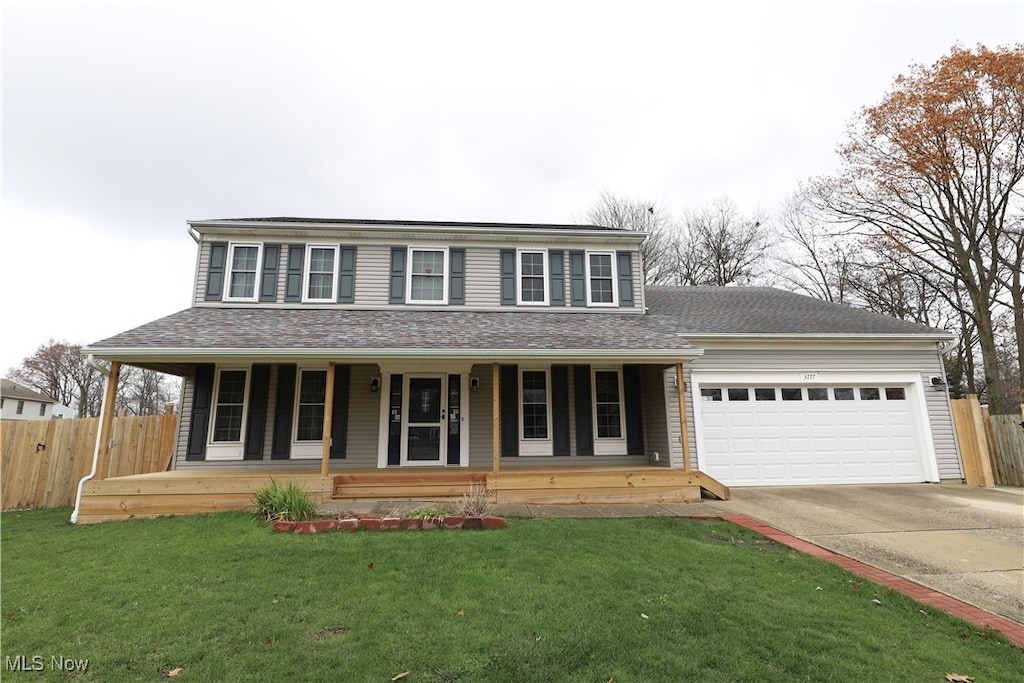 view of front facade featuring covered porch, a garage, and a front yard