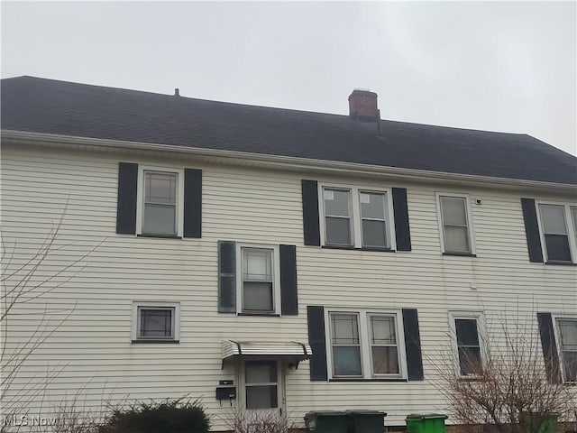 rear view of house featuring a chimney