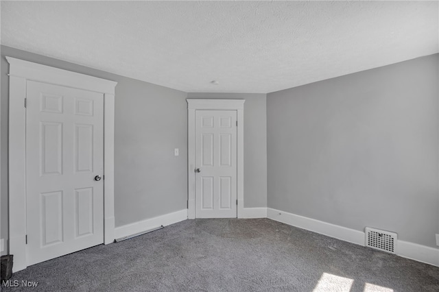 carpeted empty room with a textured ceiling