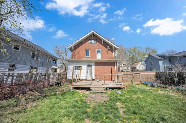 rear view of property with a lawn and a deck