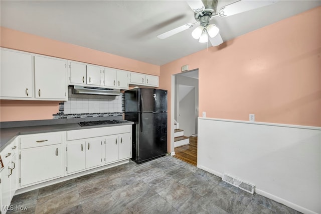 kitchen featuring white cabinets, ceiling fan, black fridge, and stainless steel gas stovetop