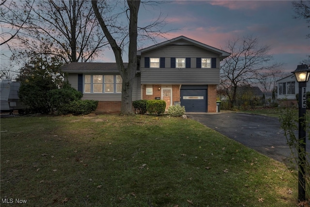 split level home featuring a lawn and a garage